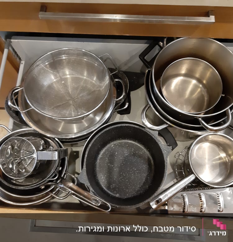 סירים ומחבתות מסודרים במגירת מטבח